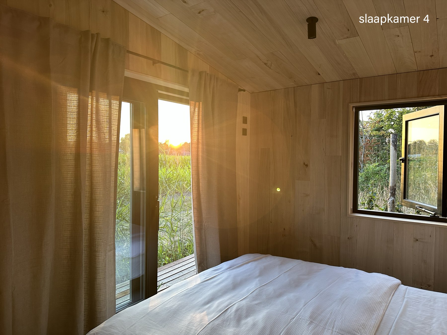 Slaapkamer vier met ramen op het landschap