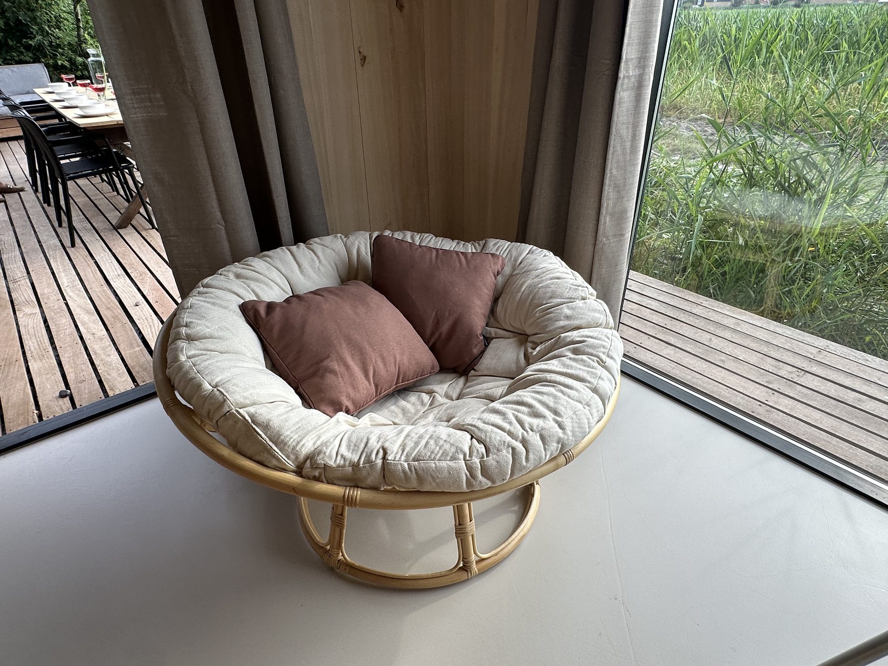 Ronde loungestoel bij de glazen hoekpui