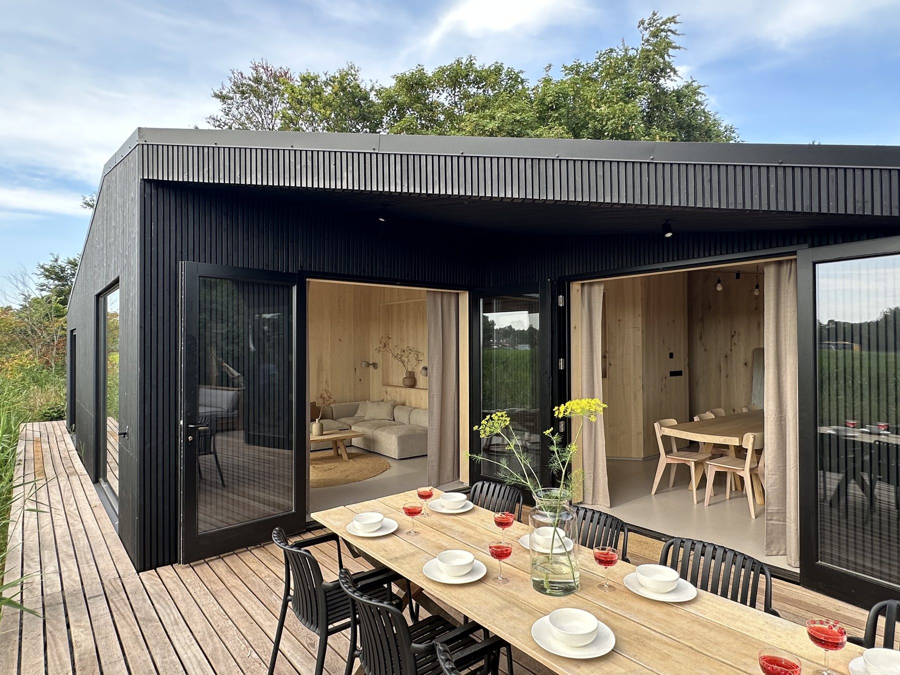 De gedekte eettafel op het ruime houten terras